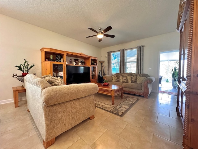 living room featuring ceiling fan and a textured ceiling