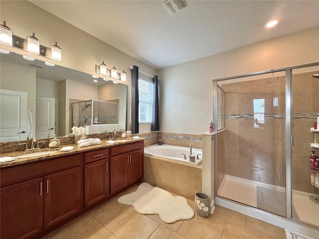 bathroom featuring a textured ceiling, plus walk in shower, vanity, and tile patterned flooring