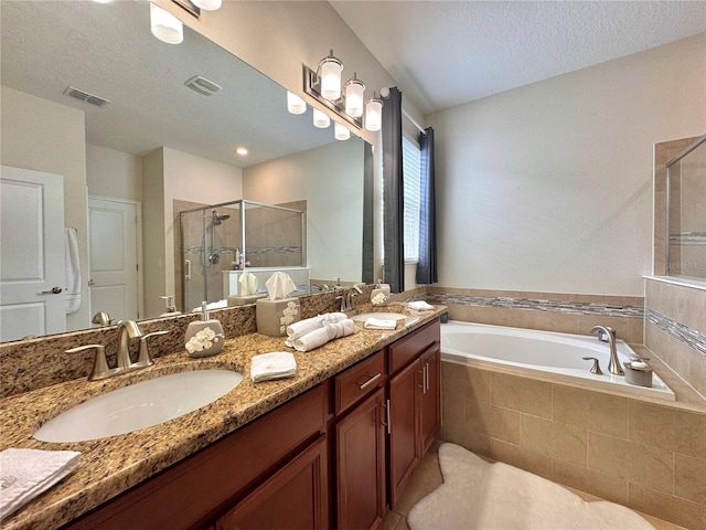 bathroom featuring plus walk in shower, a textured ceiling, and vanity