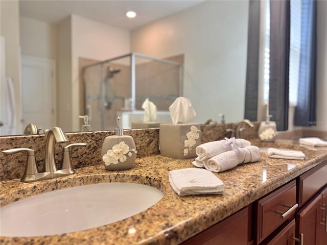 bathroom featuring walk in shower and vanity