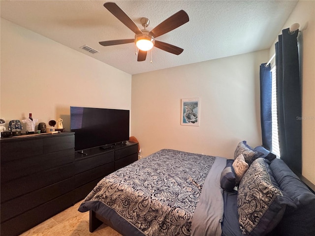 bedroom featuring ceiling fan, a textured ceiling, and multiple windows