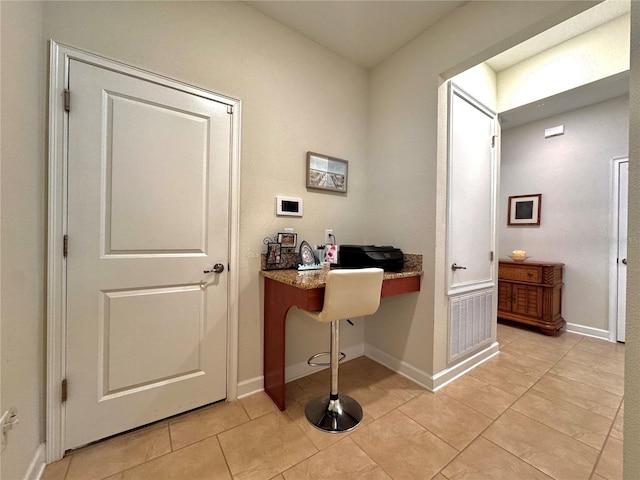 home office featuring light tile patterned flooring and built in desk