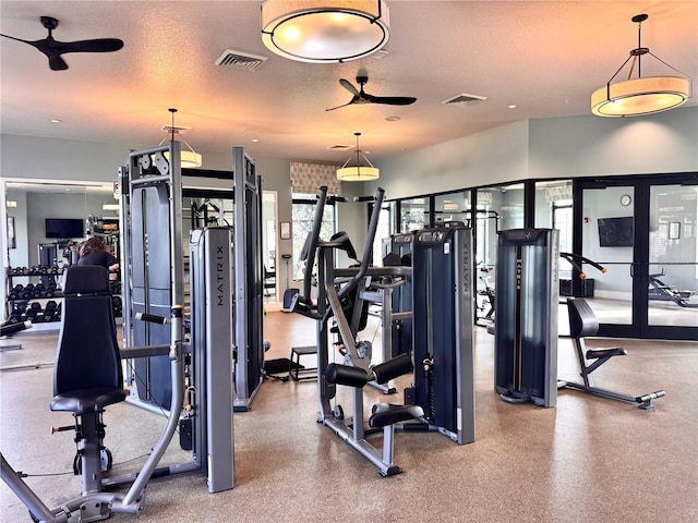 workout area with ceiling fan and a textured ceiling