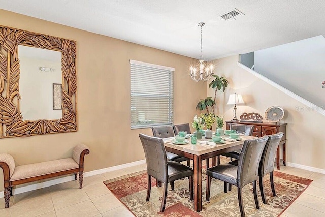 dining room with light tile patterned floors and a notable chandelier