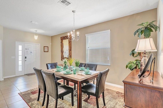 dining area with light tile patterned flooring, a chandelier, and a textured ceiling