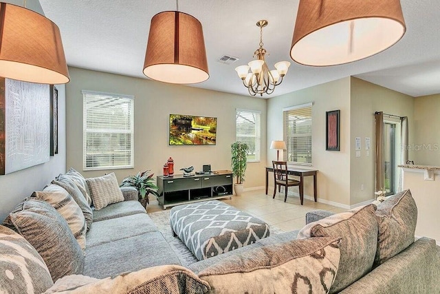 living room with plenty of natural light, light tile patterned floors, and an inviting chandelier