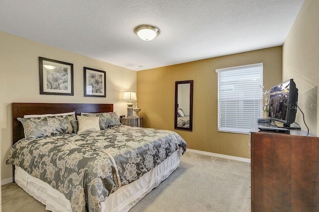 bedroom with light carpet and a textured ceiling