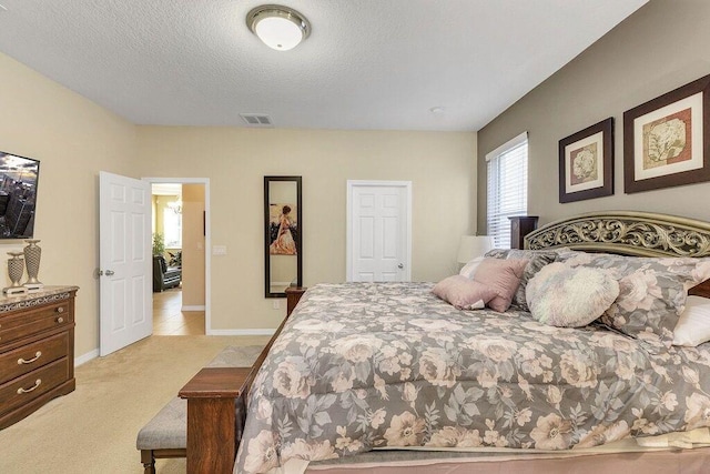 bedroom with light carpet and a textured ceiling