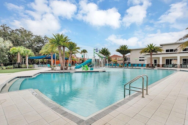 view of swimming pool with a patio and a water slide