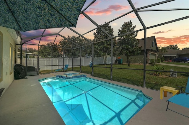 pool at dusk with a lawn, a lanai, an in ground hot tub, and a patio area