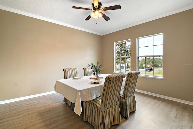 dining space with ornamental molding, a healthy amount of sunlight, and hardwood / wood-style floors