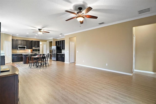 living room featuring sink, ceiling fan, crown molding, and light hardwood / wood-style flooring