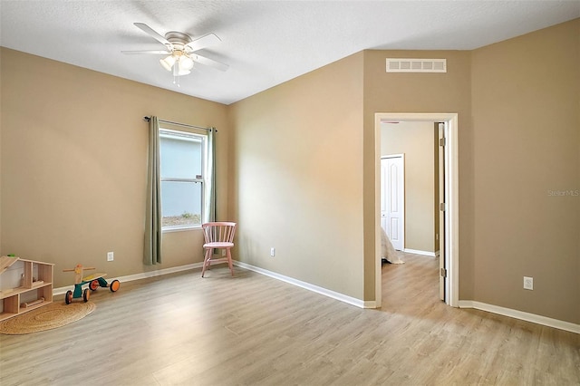 interior space with a textured ceiling, ceiling fan, and light hardwood / wood-style floors