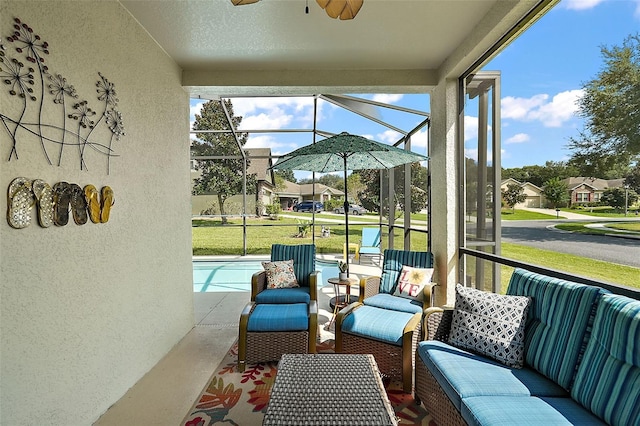 sunroom / solarium with a swimming pool, ceiling fan, and a healthy amount of sunlight