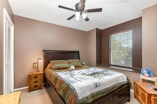 carpeted bedroom with a closet, ceiling fan, and a textured ceiling