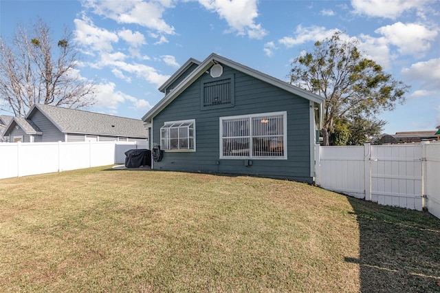 rear view of property featuring a lawn