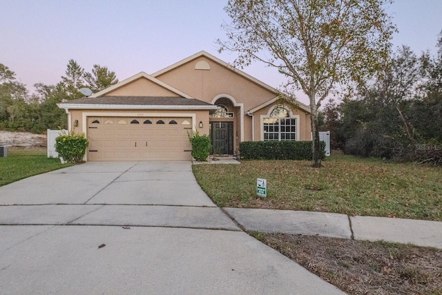 ranch-style house with a lawn and a garage