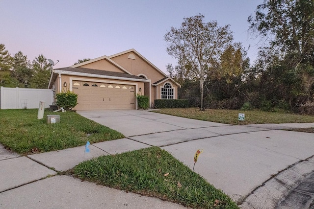 view of front of home featuring a lawn and a garage