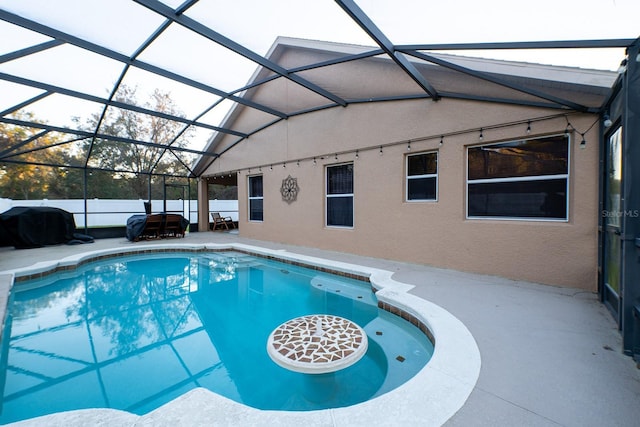 view of pool with a patio and glass enclosure