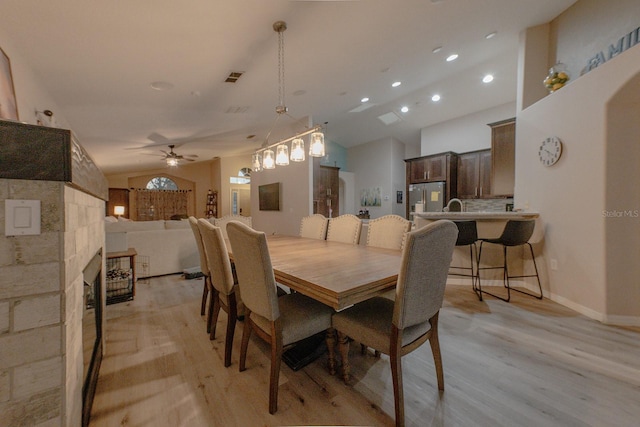 dining room featuring ceiling fan, light hardwood / wood-style flooring, and vaulted ceiling