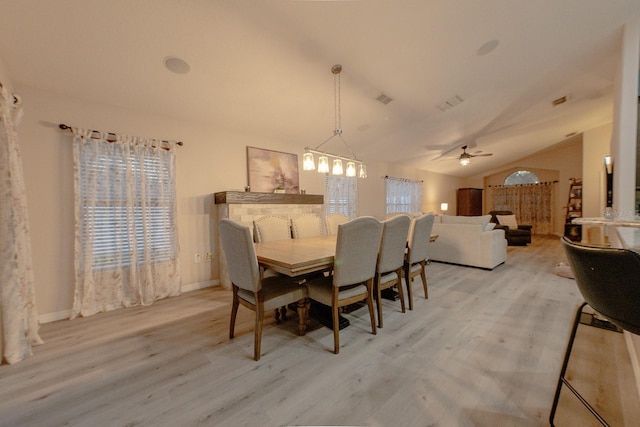 dining area with ceiling fan, light wood-type flooring, and vaulted ceiling