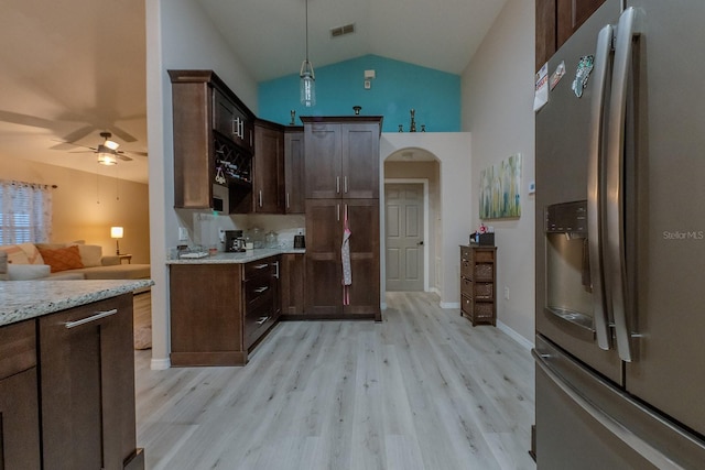 kitchen featuring light stone counters, pendant lighting, stainless steel refrigerator with ice dispenser, lofted ceiling, and ceiling fan