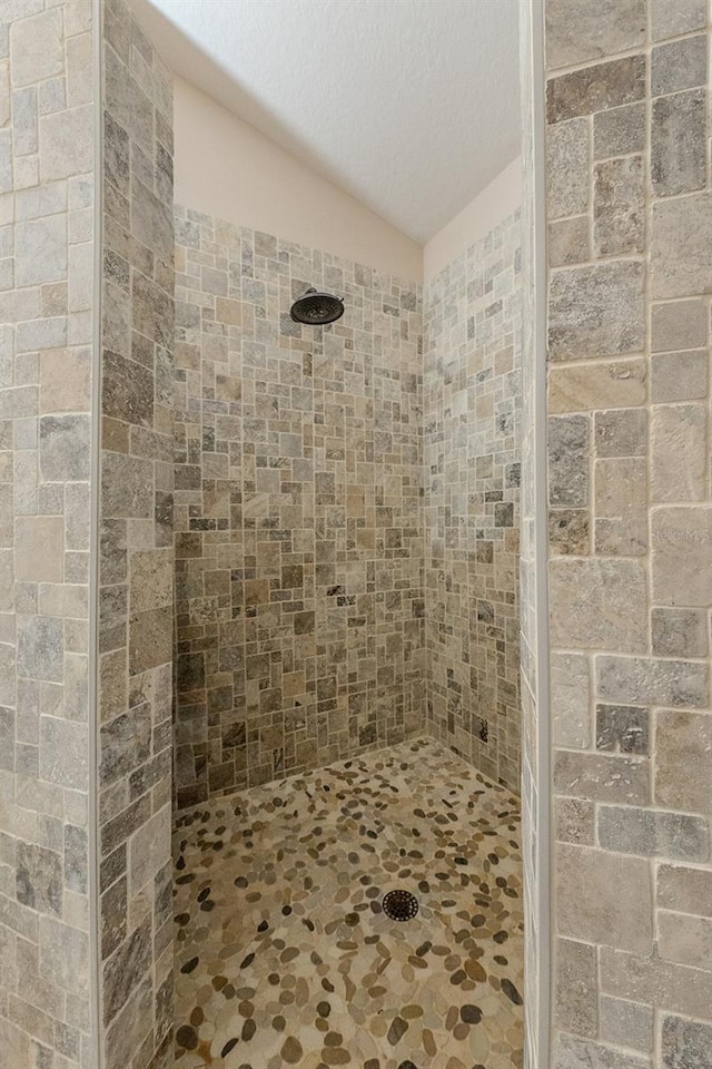 bathroom featuring a tile shower and a textured ceiling