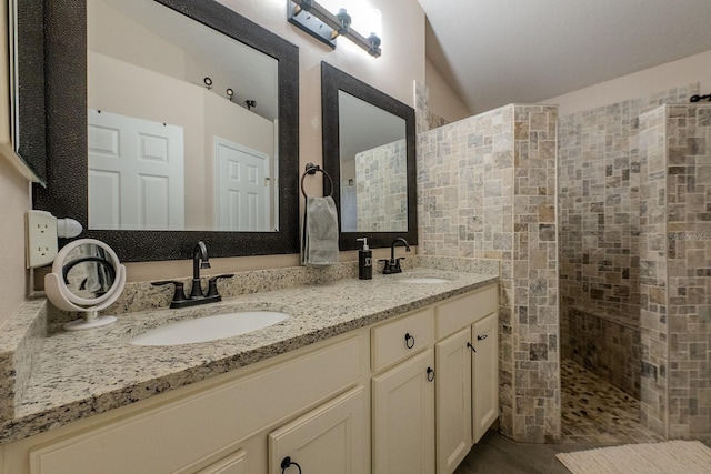 bathroom with tiled shower and vanity