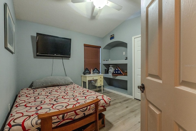 bedroom with ceiling fan, light wood-type flooring, and vaulted ceiling