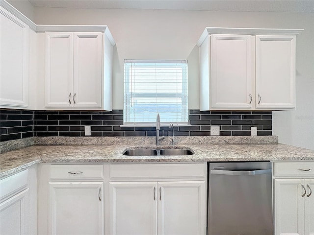 kitchen featuring stainless steel dishwasher, white cabinets, and sink