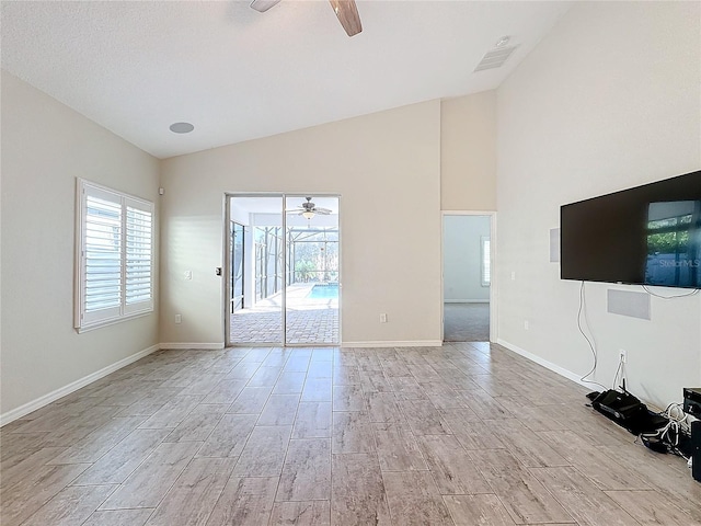 unfurnished living room with ceiling fan and vaulted ceiling