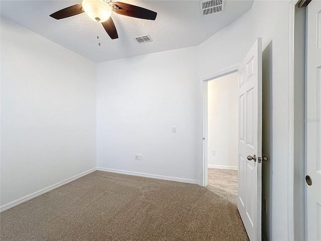 carpeted spare room with a textured ceiling and ceiling fan