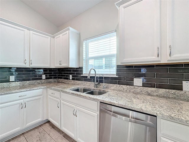 kitchen featuring tasteful backsplash, dishwasher, sink, light tile patterned flooring, and white cabinets