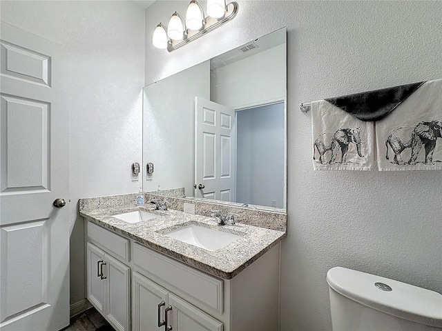 bathroom featuring toilet and vanity