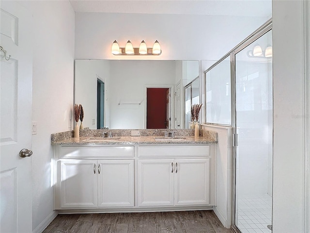 bathroom featuring walk in shower, vanity, and wood-type flooring