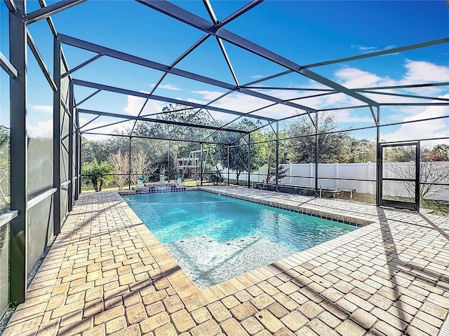 view of pool featuring glass enclosure and a patio