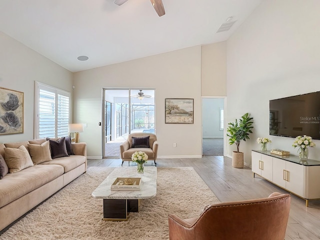 living room with ceiling fan, high vaulted ceiling, and light hardwood / wood-style floors