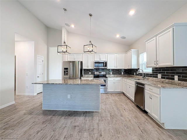 kitchen with decorative light fixtures, white cabinets, a center island, and stainless steel appliances