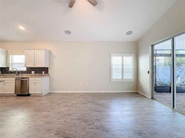 kitchen featuring white cabinets, dishwasher, a wealth of natural light, and light stone counters