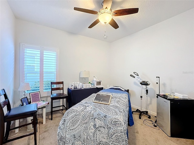 bedroom featuring ceiling fan, light carpet, and stainless steel refrigerator