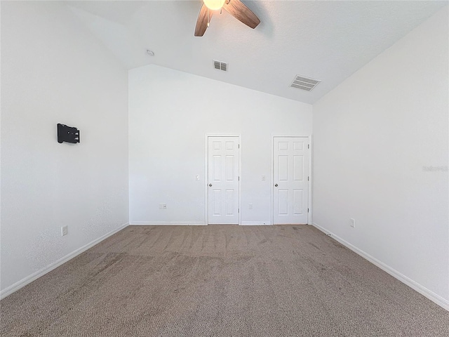 carpeted spare room with ceiling fan and high vaulted ceiling