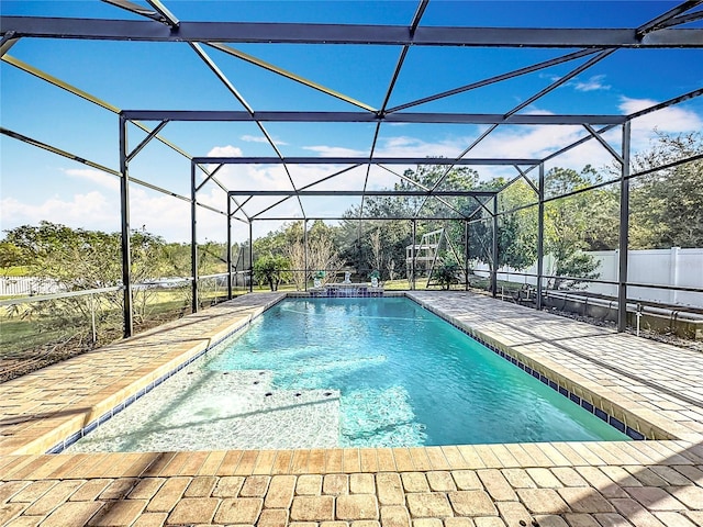 view of pool with glass enclosure and a patio