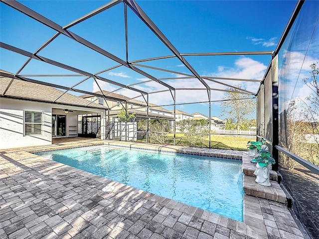 view of swimming pool with a lanai, ceiling fan, and a patio area