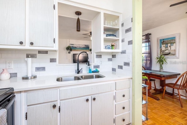 kitchen featuring light parquet floors, white cabinets, sink, hanging light fixtures, and ceiling fan