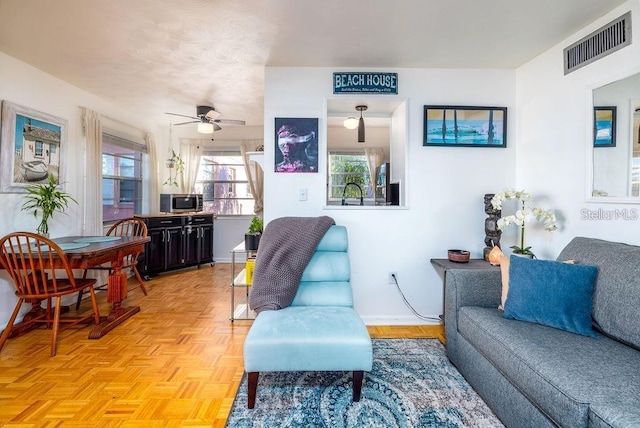 living room featuring light parquet floors and ceiling fan