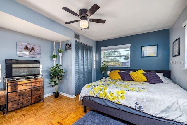 bedroom featuring ceiling fan, a closet, and light parquet flooring