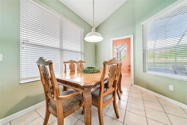 dining area featuring light tile patterned floors and vaulted ceiling