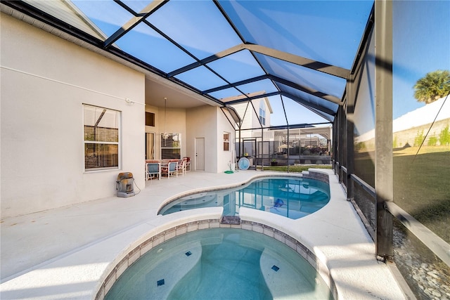 view of pool with a lanai, a patio area, and an in ground hot tub