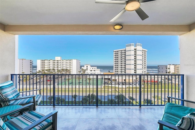 balcony with ceiling fan and a water view