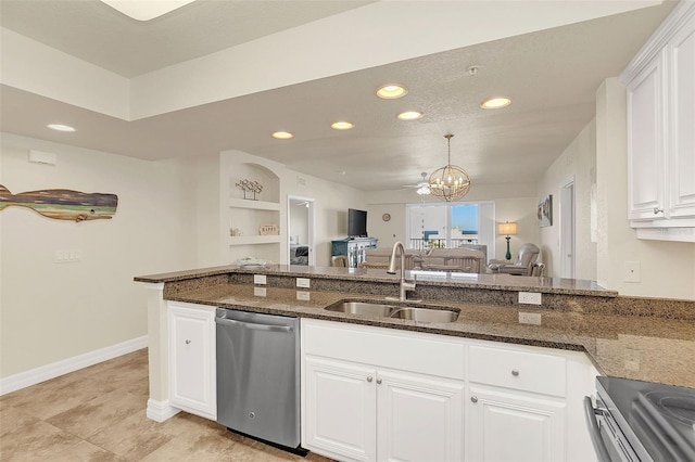 kitchen featuring stainless steel appliances, white cabinetry, dark stone counters, and sink